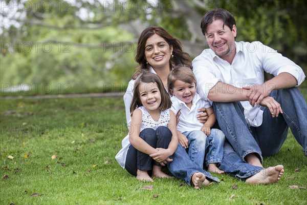 Happy family sitting together in grass