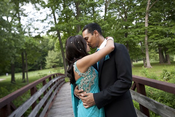 Indian wedding couple kissing on bridge