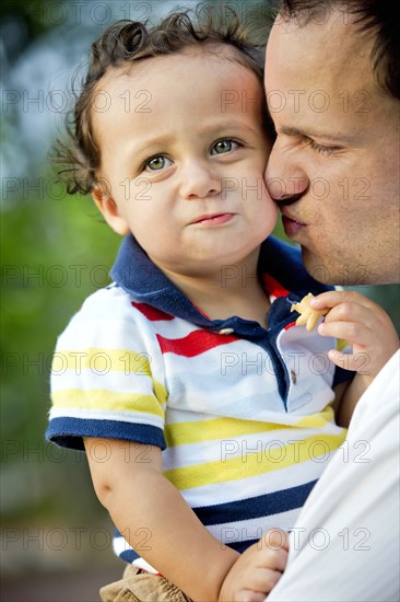 Father kissing son's cheek