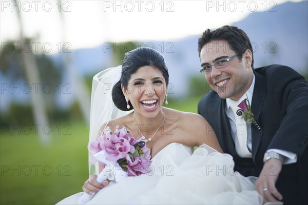 Newlywed couple smiling on golf course