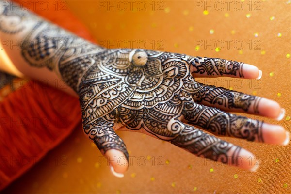 Close up of hand with intricate henna design