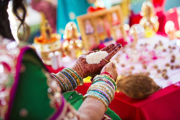 Indian woman in traditional garb with handful of rice