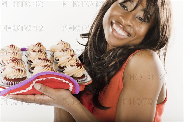African American woman holding cupcakes