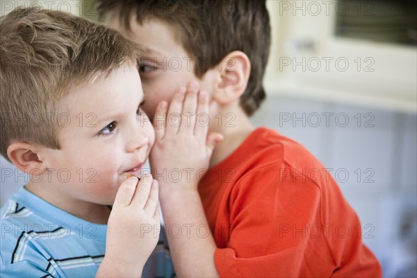 Caucasian brothers whispering together