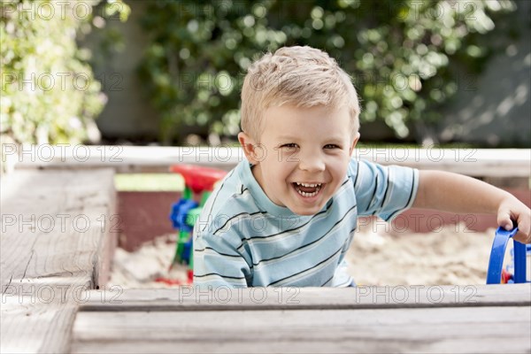 Caucasian boy playing in sandbox