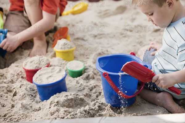 Caucasian brothers playing in sandbox