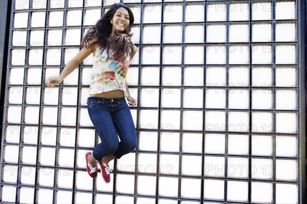 Hispanic teenager jumping in air