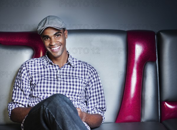 Smiling man sitting on unusual sofa