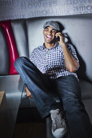 Man talking on cell phone in nightclub booth