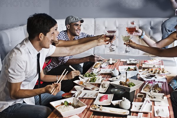 Friends toasting and eating together in restaurant