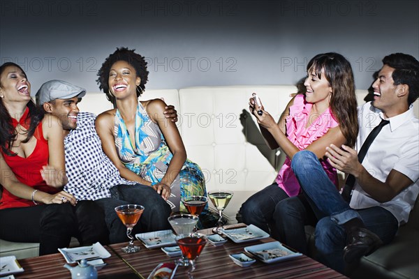 Friends drinking cocktails in nightclub