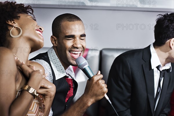 Friends singing karaoke in nightclub