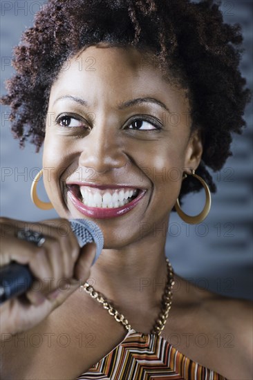 African American woman singing karaoke in nightclub