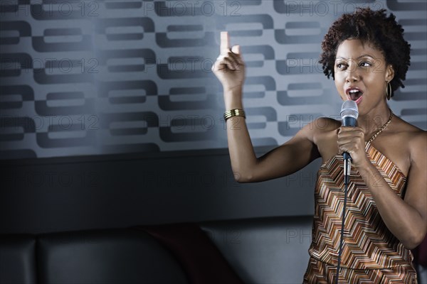 African American woman singing karaoke in nightclub