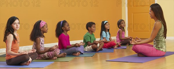 Teacher leading class of children in exercise routine