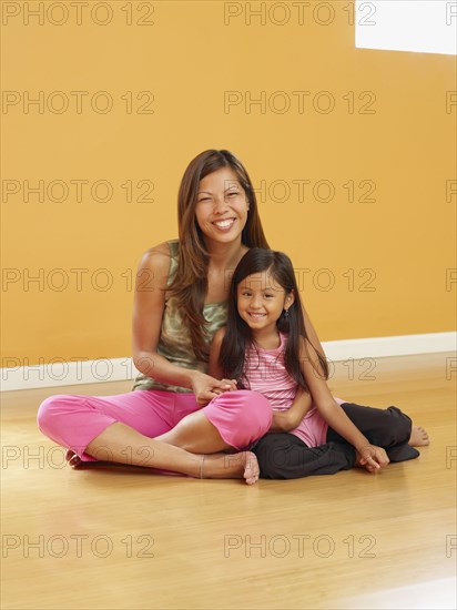 Pacific Islander woman sitting on floor with daughter