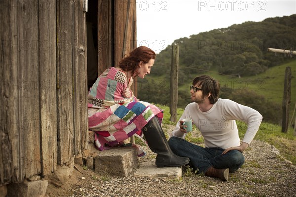 Couple relaxing by barn