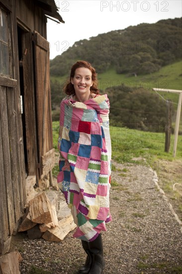 Woman wrapped in blanket outdoors