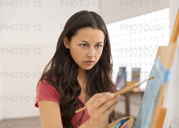 Woman painting at easel