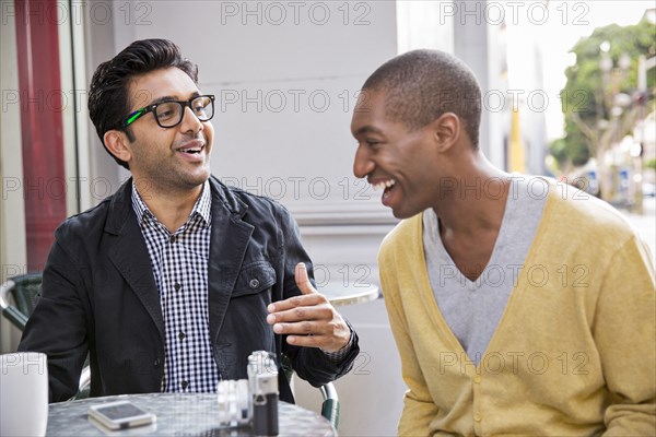 Men talking at sidewalk cafe