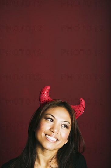 Asian woman wearing devil's horns