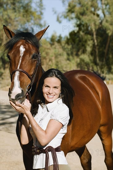 Middle Eastern woman standing with horse