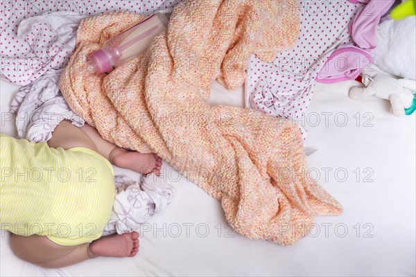 Mixed race baby girl crawling in bed