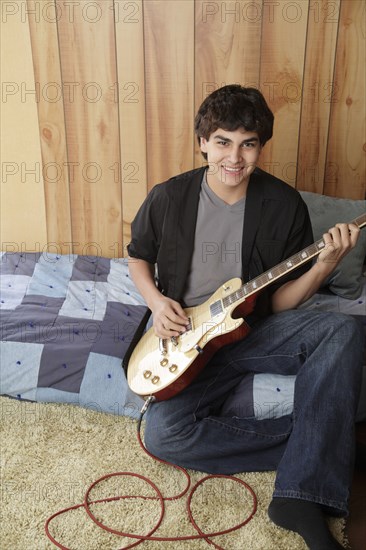 Native American teenager playing electric guitar