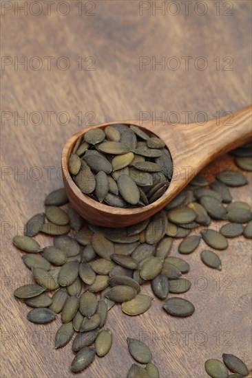 Close up of toasted pumpkin seeds in wooden spoon