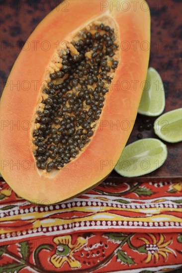 Close up of split papaya and limes