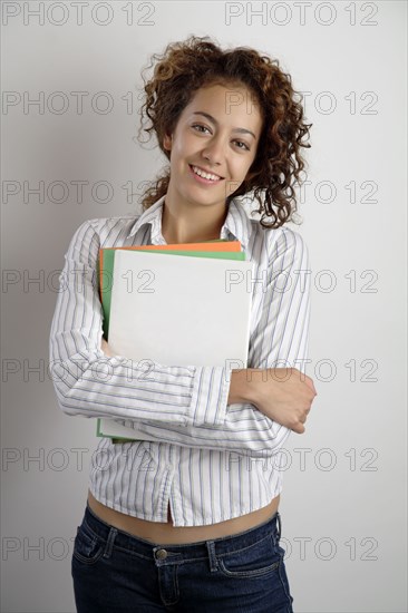 Mixed race woman holding books