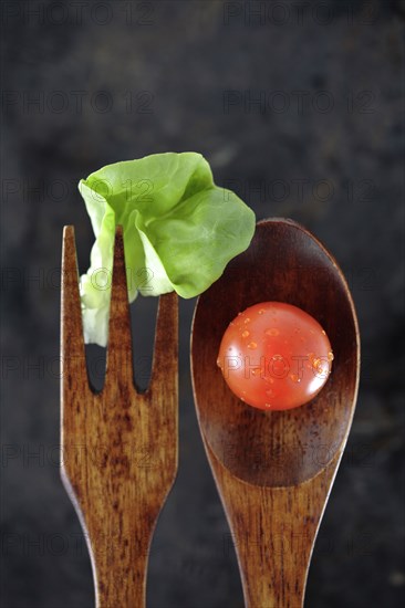 Wooden fork and spoon with lettuce and tomato