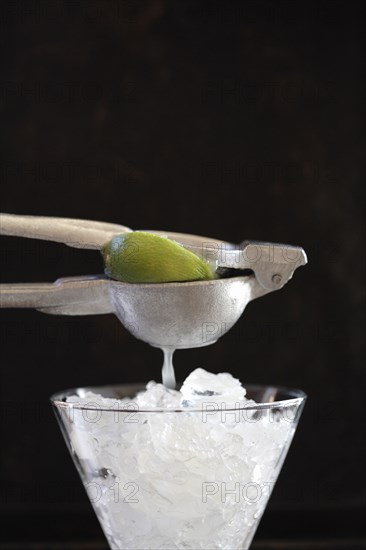 Lime being squeezed over ice