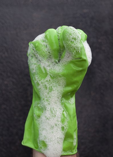 Close up of soap suds covering rubber glove