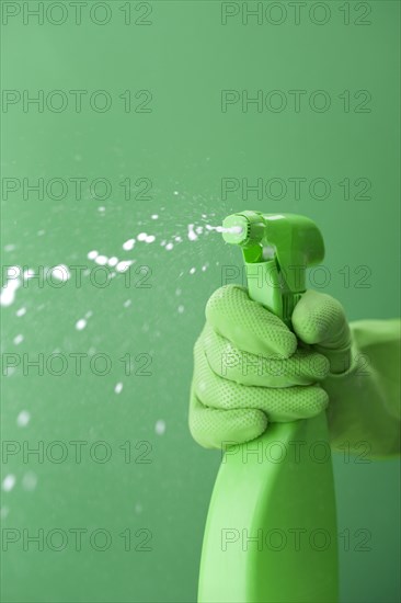 Green rubber glove squiring spray bottle