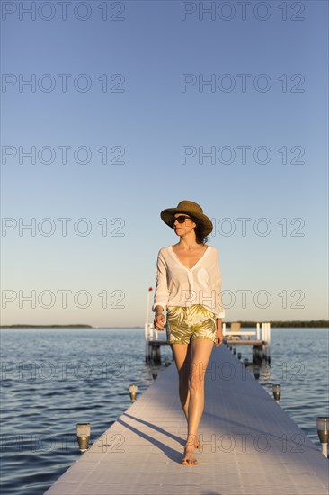 Caucasian woman walking on pier over water