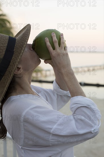 Caucasian woman drinking juice from coconut