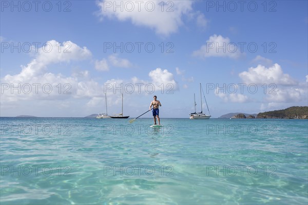 Caucasian man standing on paddle board on ocean