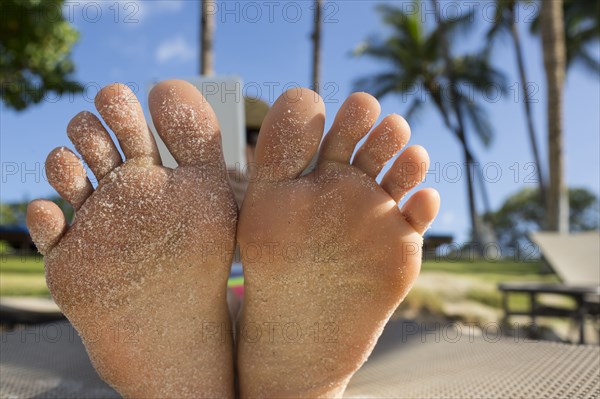 Close up of bottom of sandy feet of Caucasian woman