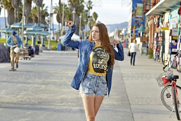 Caucasian woman walking on Venice Beach sidewalk