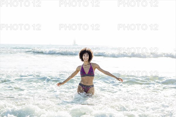 Ocean waves splashing on Mixed Race woman