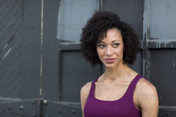 Smiling Mixed Race woman leaning on door