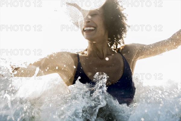 Ocean waves splashing on Mixed Race woman