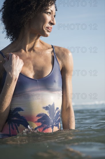 Mixed Race woman wading in ocean