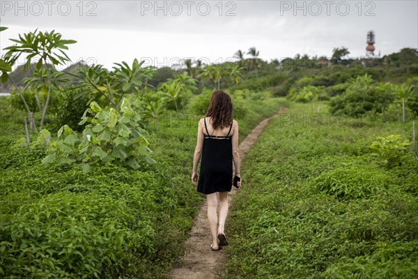 Woman walking on path through foliage