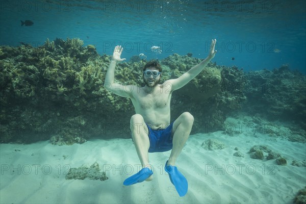 Portrait of smiling man swimming underwater in ocean