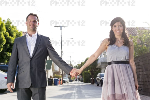 Smiling couple holding hands in alley