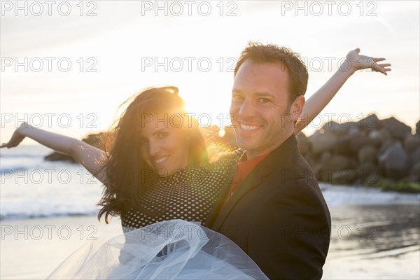 Portrait of couple celebrating on beach