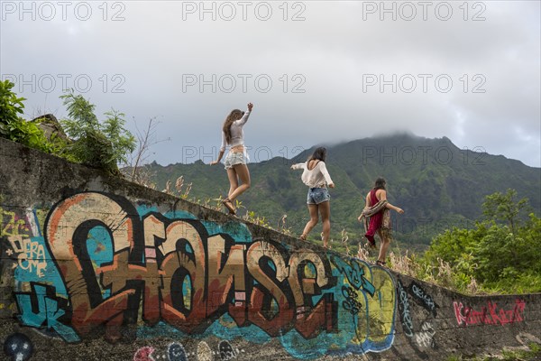 Friends walking on graffiti wall near mountain