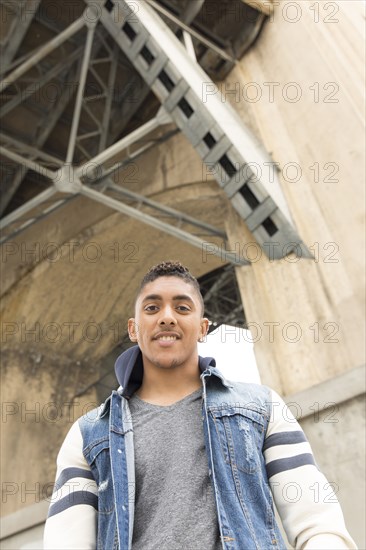 Portrait of smiling Mixed Race man under bridge